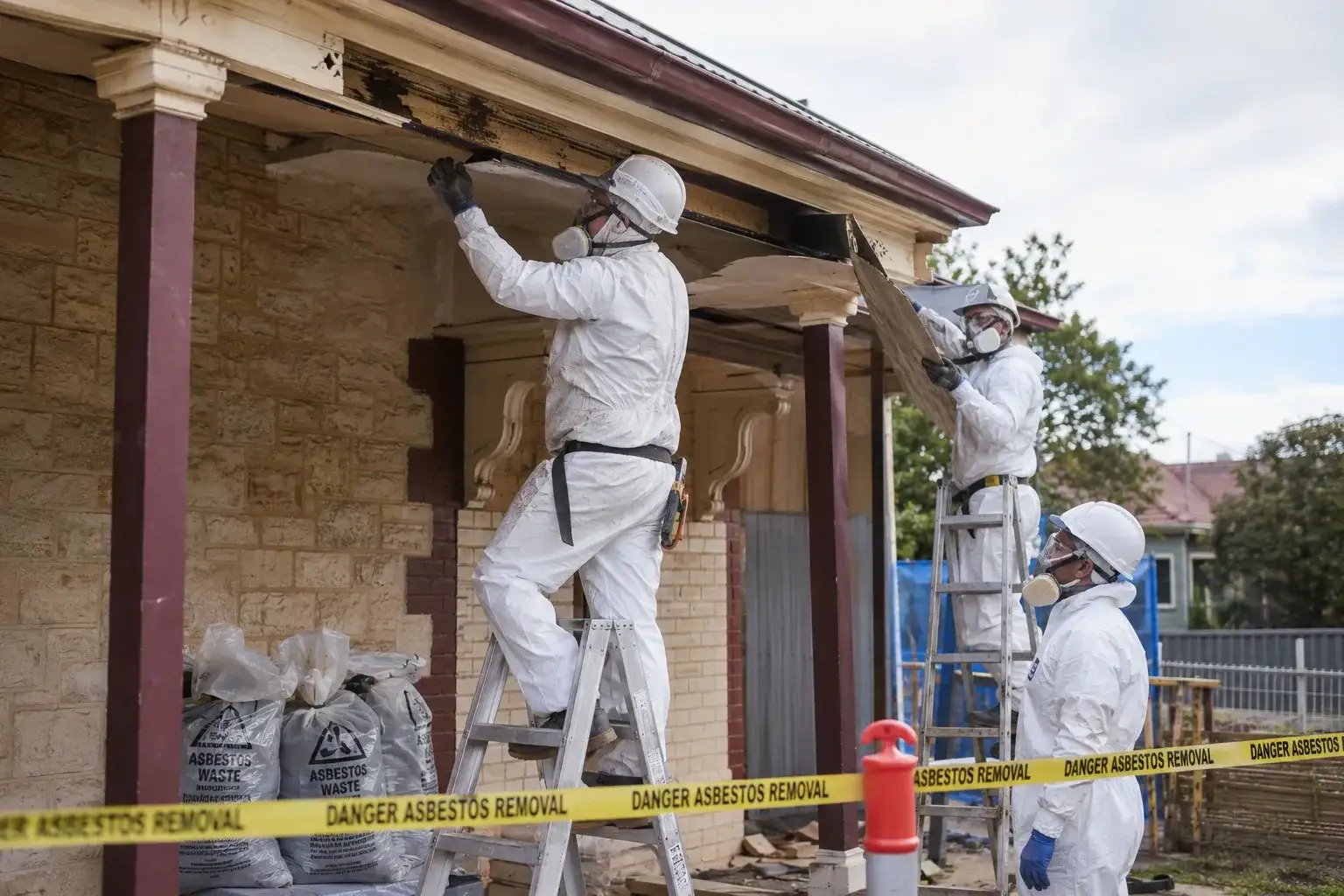 Asbestos removal specialists working on a heritage Adelaide home with danger tape and ladders